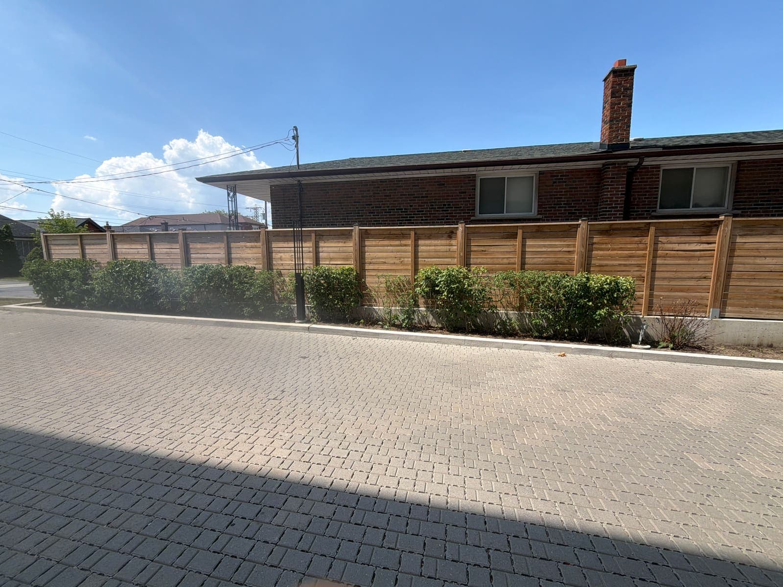Angled view of a permeable paver driveway in front of a brick bungalow