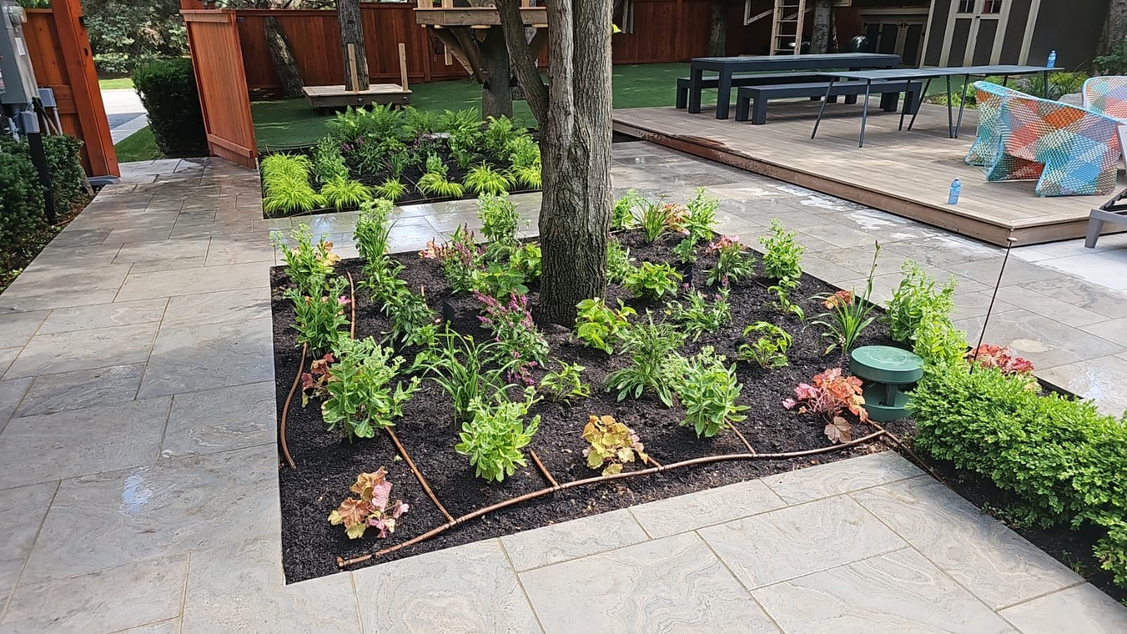 Ground-level view of a large-format slab patio with a planted island